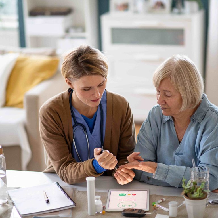 Nurse, caregiver or healthcare worker with senior woman patient, measuring blood glucose indoors.
