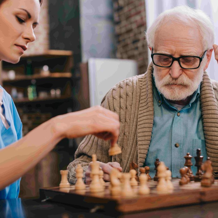 Nurse and senior man playing chess Nurse and senior man playing chess